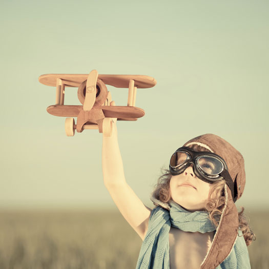 Enfant tenant un avion de bois en l'air